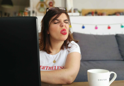 Marie devant son ordinateur qui tire la langue à la caméra